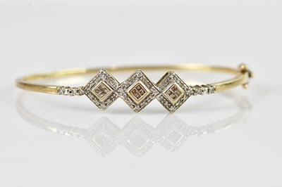 Lot 1222 - A yellow metal diamond set hinged snap bangle,...