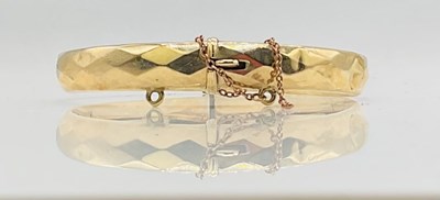 Lot 726 - A 9ct yellow gold hinged oval snap bangle,...