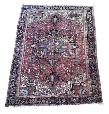 Lot 118 - An antique Persian Heriz red ground carpet,...