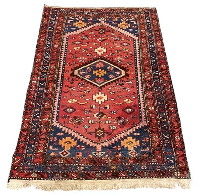 Lot 139 - An antique Persian red ground carpet, with...