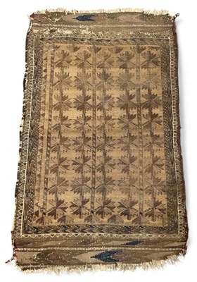 Lot 140 - An antique Belouch beige ground rug, with...