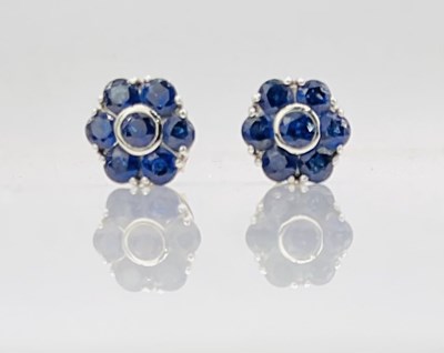Lot 661 - A pair of 18ct white gold and sapphire floral...