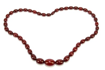 Lot 1451 - A single strand cherry amber bead necklace,...
