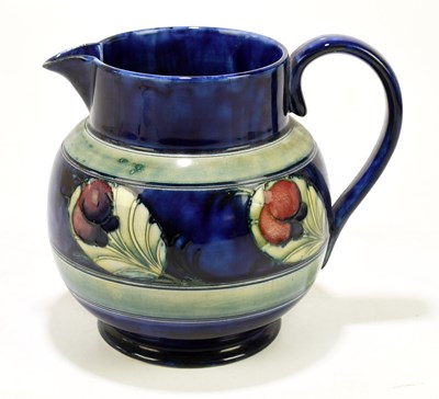 Lot 28 - WILLIAM MOORCROFT; a bulbous jug decorated in...