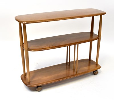 Lot 68 - ERCOL; a light elm three-tier book trolley...