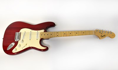 Lot 202 - SQUIER; a red Stratocaster electric guitar...