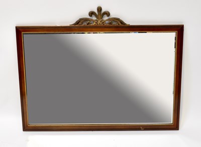 Lot 84 - A mahogany wall-hanging mirror with carved...