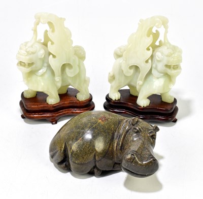 Lot 631 - A pair of decorative Chinese moulded glass dragons on wooden stands