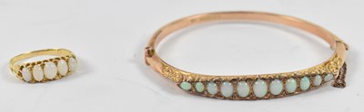 Lot 851 - A 9ct gold bangle set with eleven opals,...