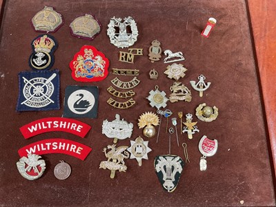 Lot 144 - A group of cap badges, also cloth badges, a...