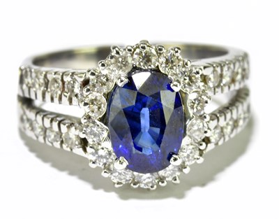 Lot 18 - An 18ct white gold sapphire and diamond ring,...