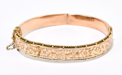 Lot 1437 - A 9ct rose gold hinged oval bangle with...