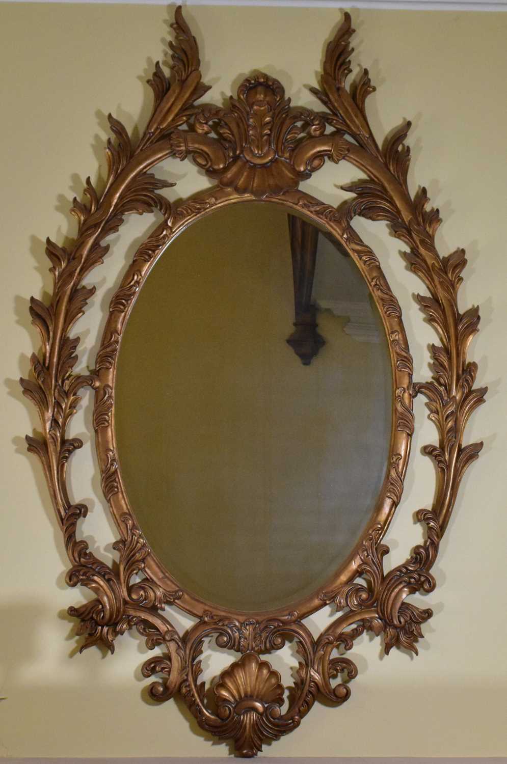 Lot 2933 A large bevelled edge oval mirror in ornate