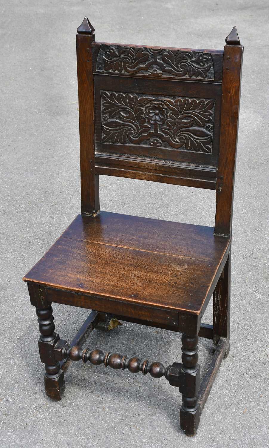 Lot 1666 - An 18th century carved oak hall chair, 95cm.