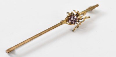 Lot 928 - A yellow metal bar brooch set with purple...