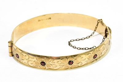 Lot 187 - A 9ct rolled gold and garnet set snap bangle.