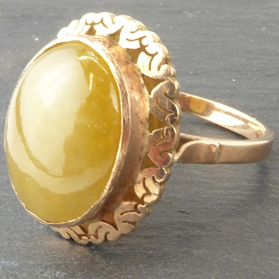 Lot 1032 - A 9ct rose gold ring with bezel set oval jade...