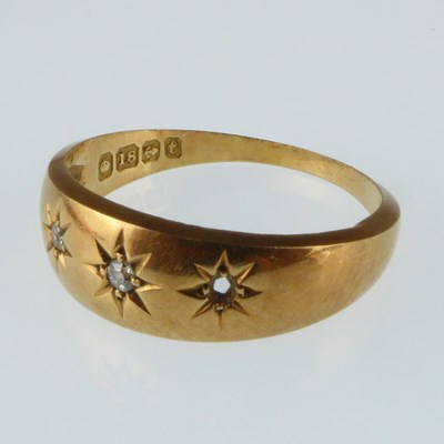 Lot 1086 - An 18ct gold ring set with three tiny diamonds...