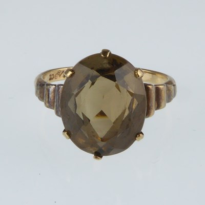 Lot 1100 - A 9ct gold dress ring with claw set smoky...