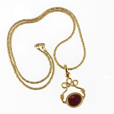 Lot 1241 - An 18ct gold swivel pendant, one side with...