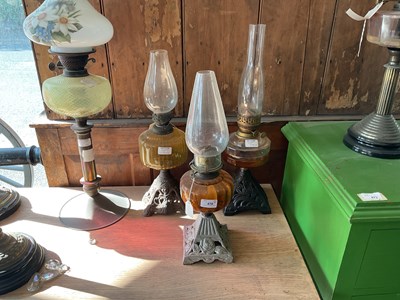 Lot 478 - Three early 20th century oil lamps with cast...