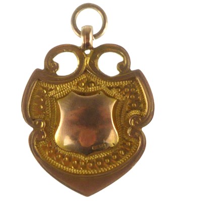 Lot 1243 - A 9ct gold shield-shaped prize fob, approx. 3.8g.