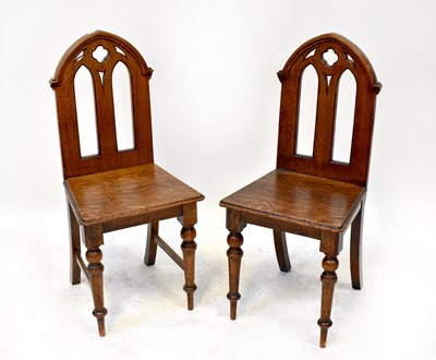 Lot 44 - A pair of oak hall chairs, the arched tops...