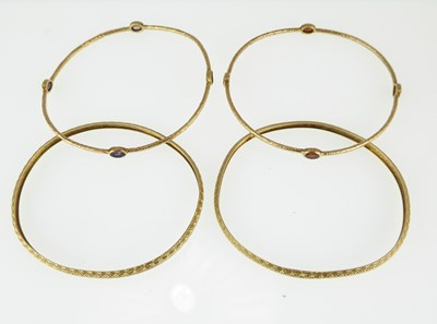 Lot 1184 - Two pairs of yellow metal bangles, one pair...