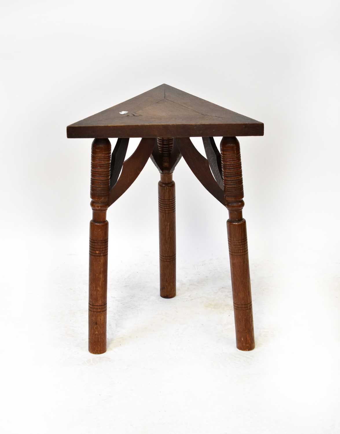 Lot 68 - An oak triangular occasional table raised on