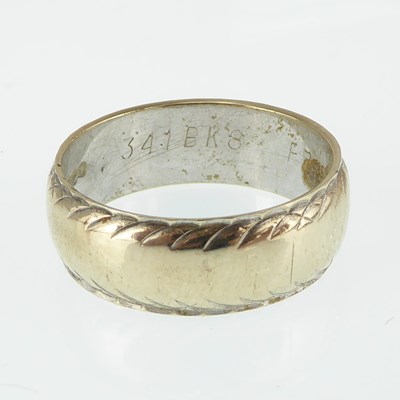 Lot 1107 - A 9ct white gold band ring with serrated edge...