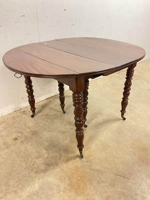 Lot 509 - A French mahogany pull-out dining table on...