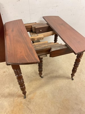 Lot 509 - A French mahogany pull-out dining table on...