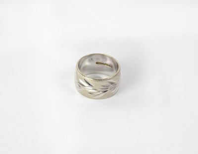 Lot 1074 - A 9ct white gold diamond cut wedding band,...