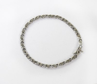 Lot 1177 - A 9ct white gold tennis bracelet set with...