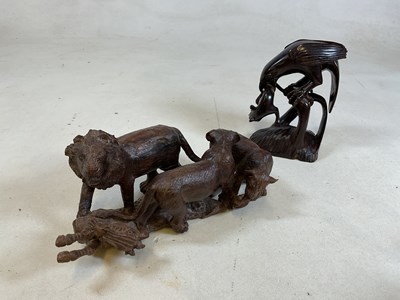 Lot 13 - An African carved wooden group of animals,...