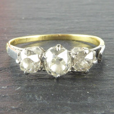 Lot 1023 - An 18ct gold ring, the principal claw set...