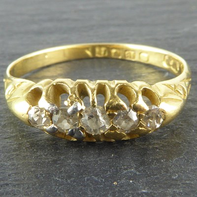 Lot 1059 - An 18ct gold ring set with five graduated claw...