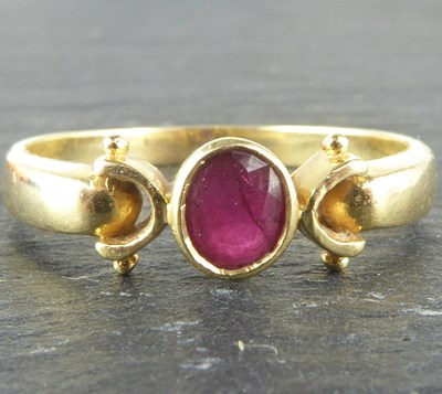 Lot 1120 - A 14ct gold ring with oval bezel set ruby,...