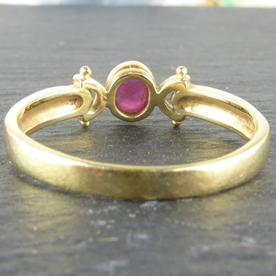 Lot 1120 - A 14ct gold ring with oval bezel set ruby,...