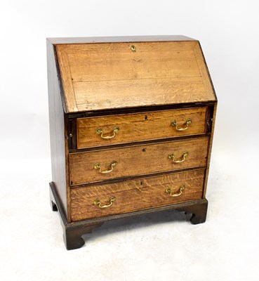 Lot 64 - A George III oak bureau with fitted interior,...