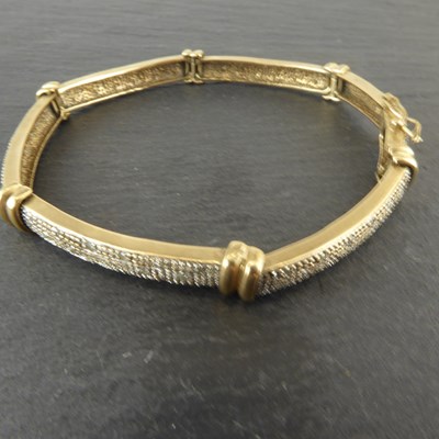 Lot 1181 - A gold hinged bracelet with six panels...