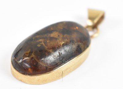 Lot 655 - A 9ct yellow gold amber set pendant, length...