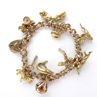 Lot 1169 - A 9ct rose gold charm bracelet with nine gold...