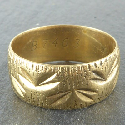 Lot 1122 - A 9ct gold band ring with textured pattern,...