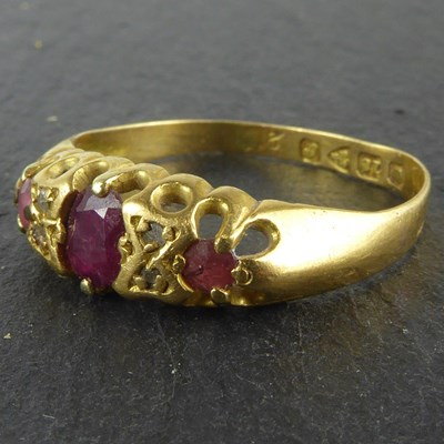 Lot 1114 - An 18ct gold ring, claw set ruby flanked by...