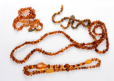 Lot 1266 - Three strands of amber-coloured beads (3).