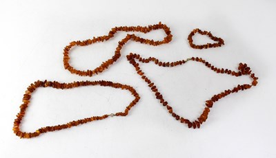 Lot 1089b - Three strands of irregular cut amber-coloured...