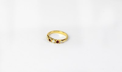 Lot 1090 - An 18ct yellow gold ring set with two rubies...