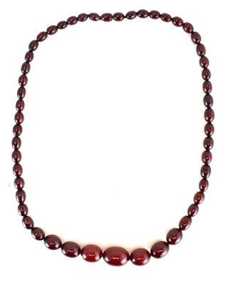 Lot 1265 - A string of graduated amber-style beads,...