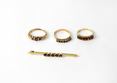Lot 1298 - Three 9ct gold rings set with garnets, stamped...